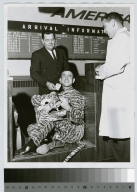 Student activities, Rochester Institute of Technology Vice President for Student Affairs, Dr. James B. Campbell and an unidentified student checking the student mascot "tiger's" baggage claim ticket, 1963