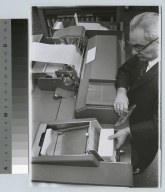 Academics, computer science, Rochester Institute of Technology data processing instructor loading punch cards into a computer, [1968-1980]