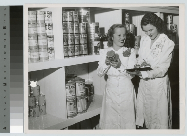 Academics, two unidentified students in Food Administration examining cans, [1949-1950]