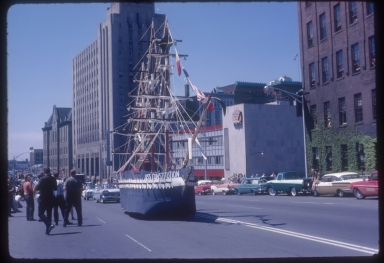 Rochester Institute of Technology float, "The USS Constitution" rides down a Rochester street in 1962 spring weekend parade.