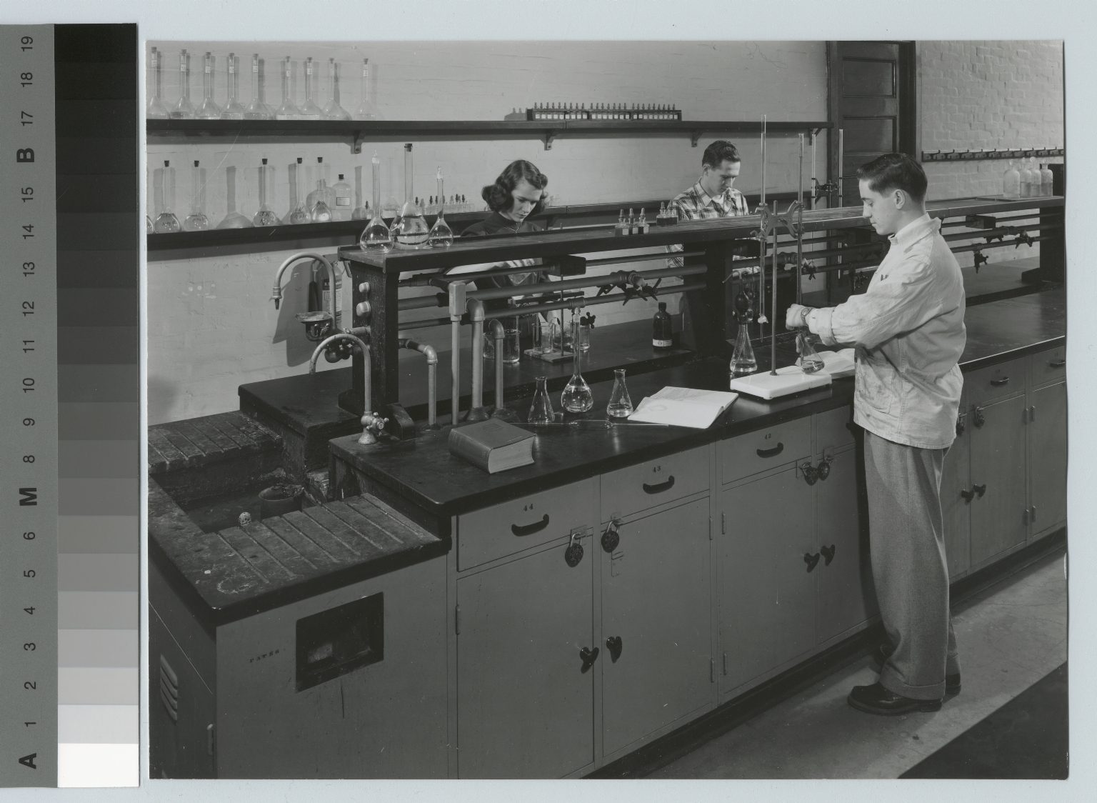 Academics, chemistry, three Rochester Institute of Technology students working on experiments in a chemistry lab, [1945-1955]