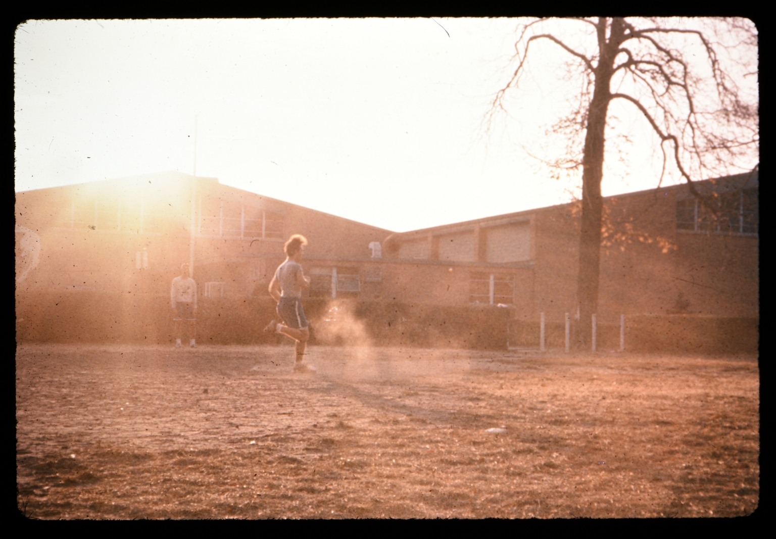 Unidentified person runs in a dusty yard